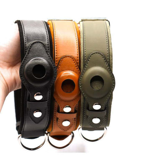 Hand holding black, brown, and green leather camera straps with silver hardware and circular cutouts