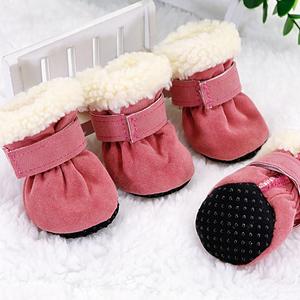 Set of four pink dog boots with thick white fleece lining and anti-slip black soles on white surface