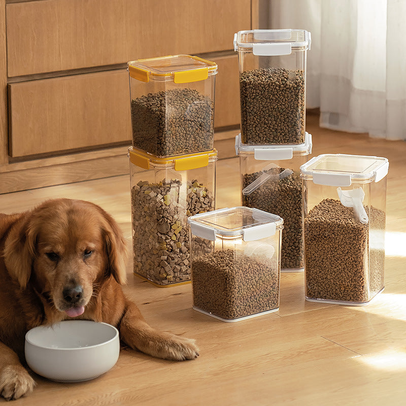 Golden retriever lying on wooden floor beside white bowl and clear storage containers filled with dry dog food