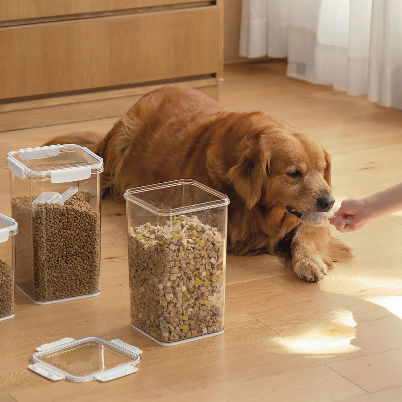 Golden retriever eating food from a scoop next to clear plastic containers filled with dog food