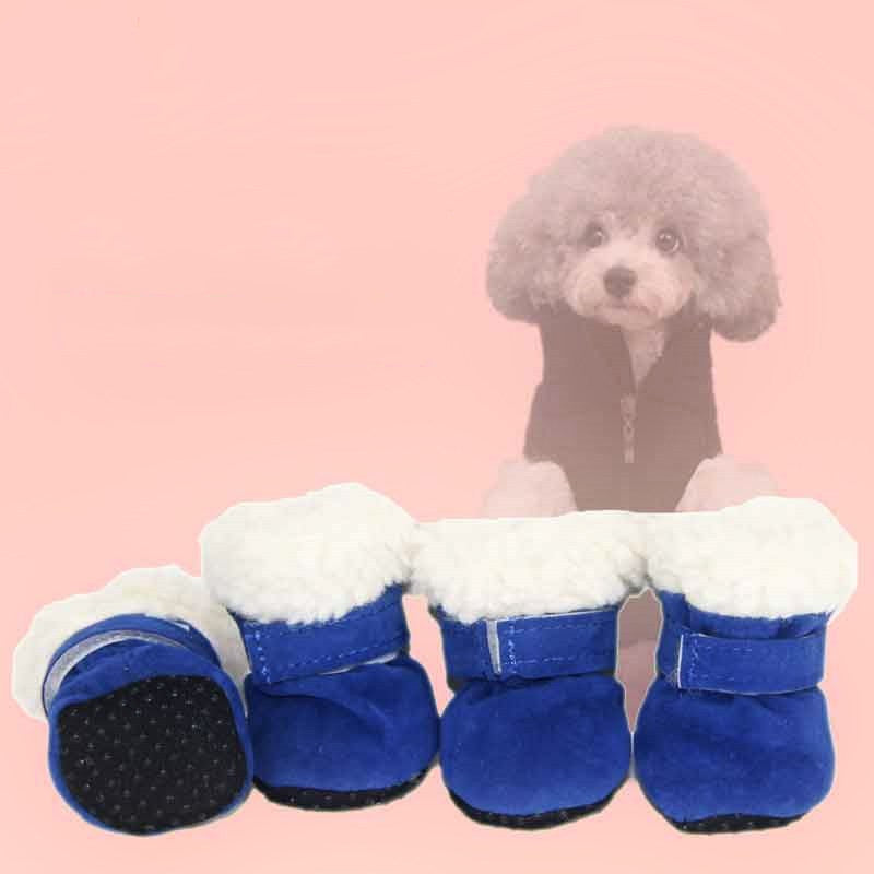 Blue dog boots with white fleece lining and anti-slip soles displayed in front of a small poodle wearing a black jacket