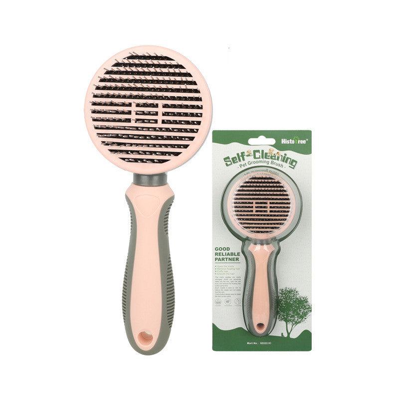 Self-cleaning pet grooming brush with pink handle and black bristles, packaged for sale