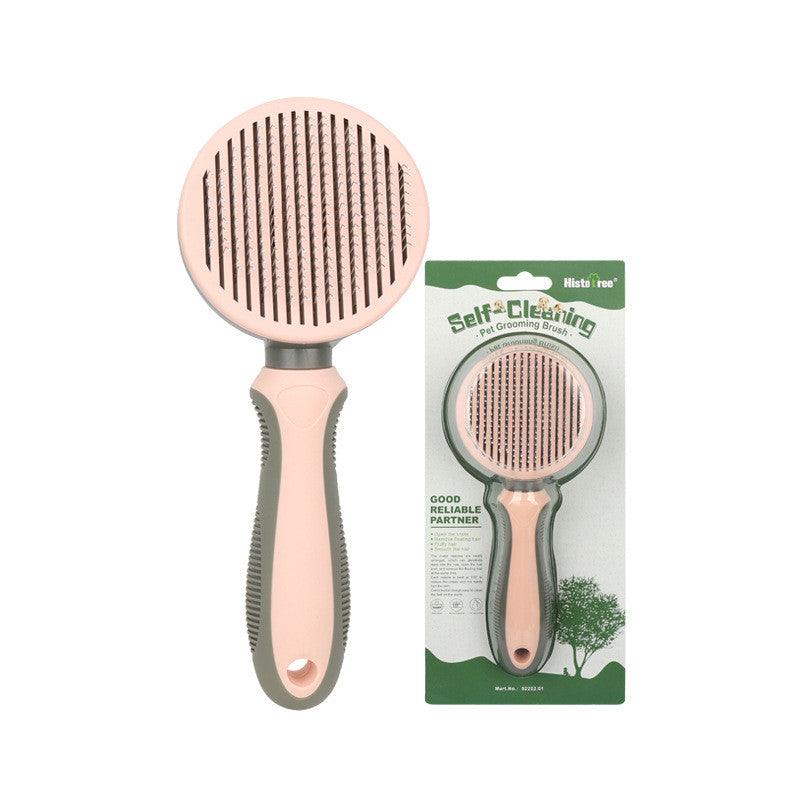 Self-cleaning pet grooming brush with pink and gray handle, displayed with retail packaging