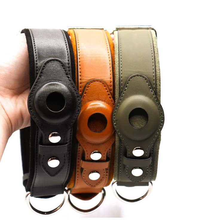 Hand holding black, brown, and green leather camera straps with silver hardware and circular cutouts